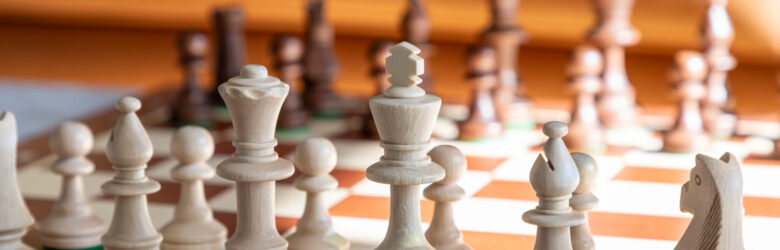 Close-up of chess pieces on a wooden board, representing strategic thinking in software development