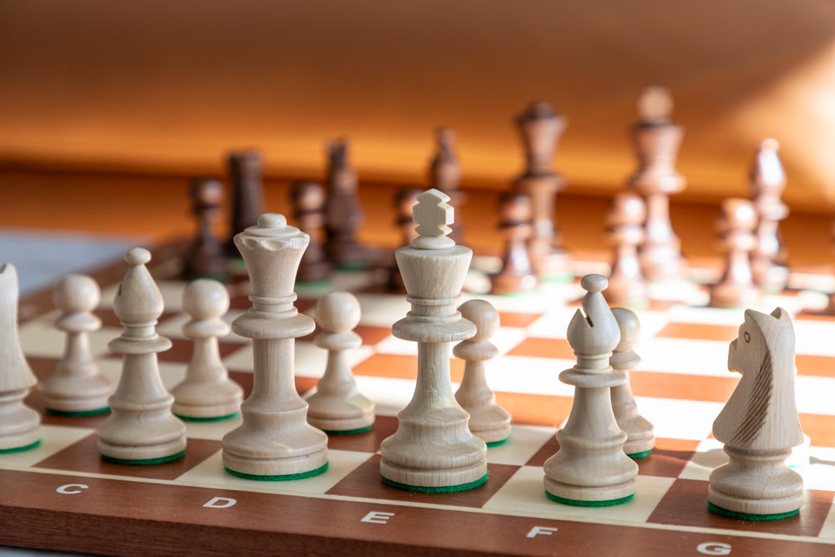 Close-up of chess pieces on a wooden board, representing strategic thinking in software development