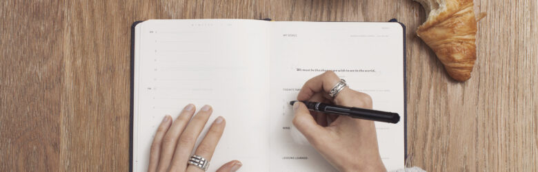 Person writing in a journal, note-taking