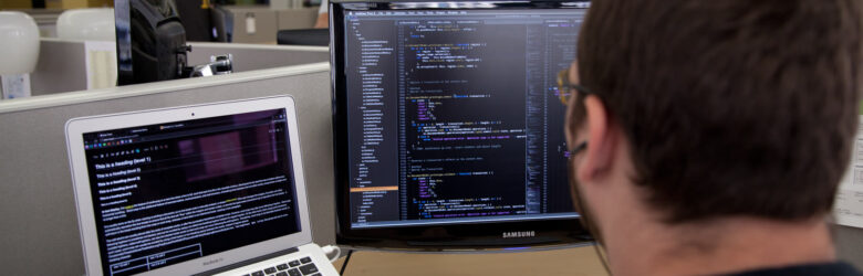 A developer's workspace showing code on a monitor, representing enterprise security and technology in the AI era
