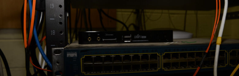 A data center server rack with multiple networking devices and cables connected