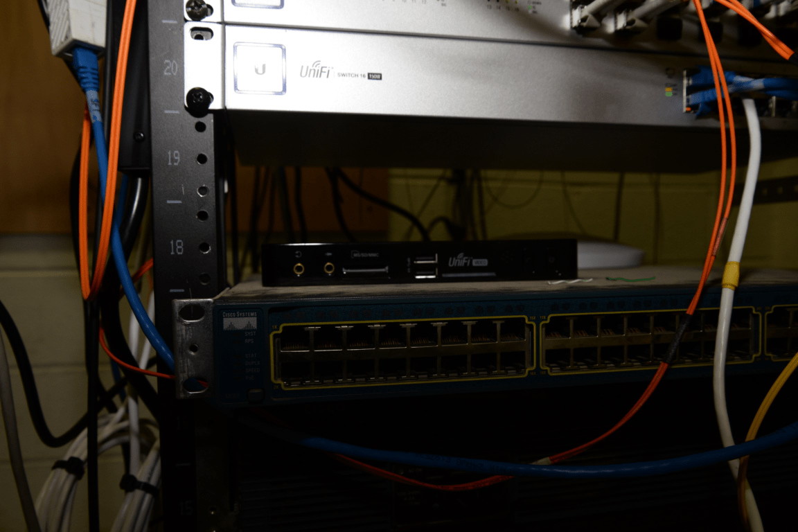 A data center server rack with multiple networking devices and cables connected