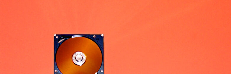 Close-up of an open hard disk drive showing internal components — representing data storage and database technology