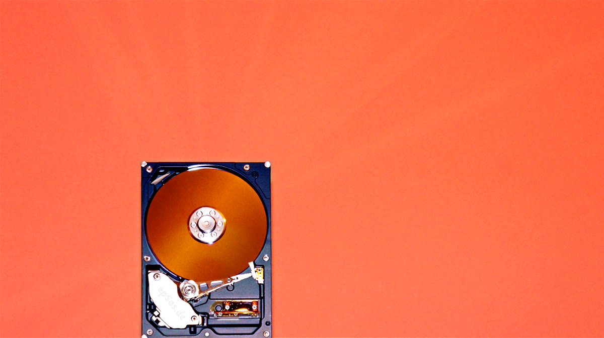 Close-up of an open hard disk drive showing internal components — representing data storage and database technology