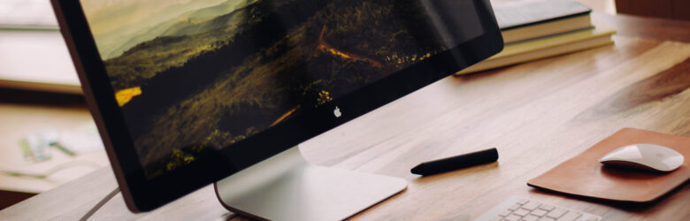 A modern desk workspace setup with computer, representing writing and content creation