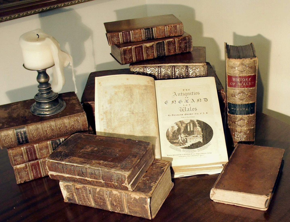 Antique books with a candle, representing the rare physical books used for AI training data