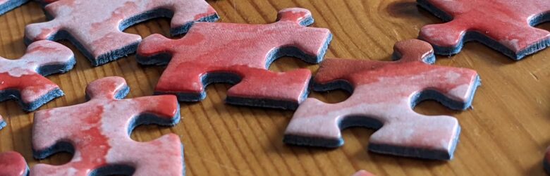 Red jigsaw puzzle pieces scattered on a surface, representing how GhostSplice splits one malicious instruction into harmless fragments