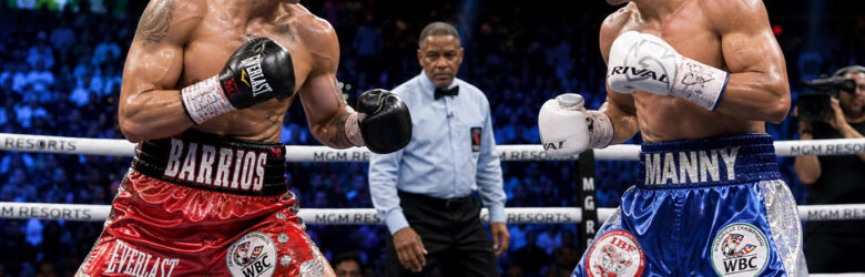 Two welterweight boxers facing off under bright arena lights during a championship fight