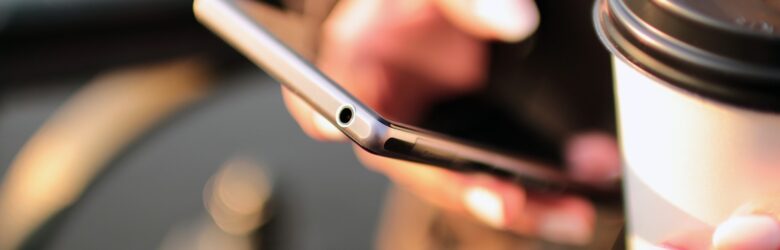 Person holding a smartphone and coffee, representing giving an AI assistant access to your personal data