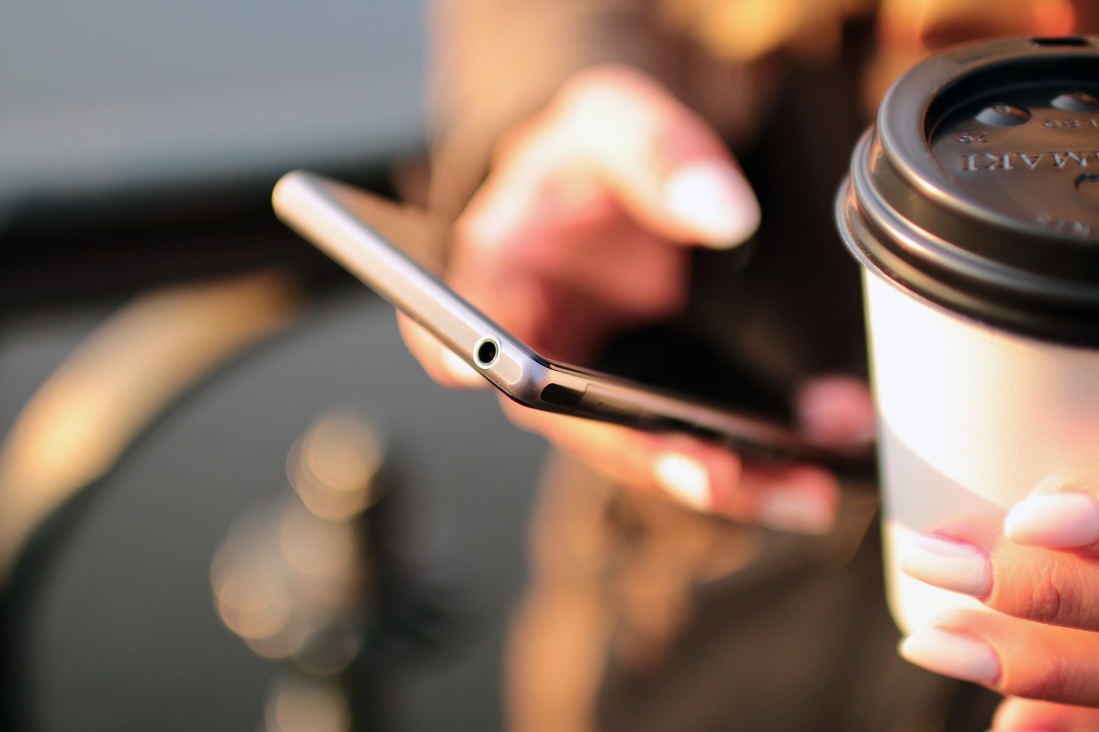 Person holding a smartphone and coffee, representing giving an AI assistant access to your personal data