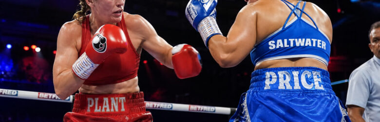 Two female middleweight boxers in a boxing ring under bright lights