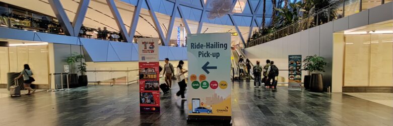 Ride-hailing pick-up area with Grab Club signage at Changi Airport in Singapore