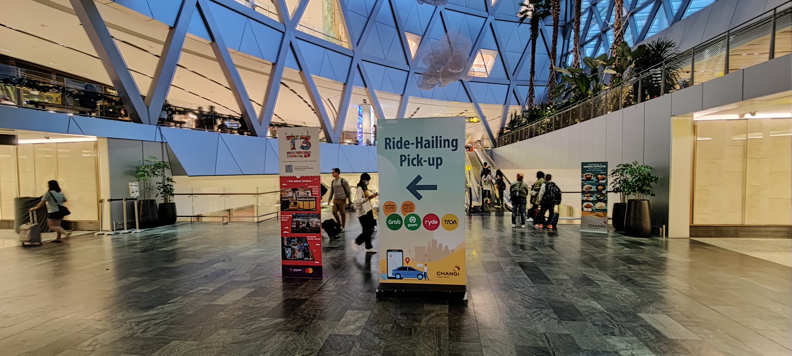 Ride-hailing pick-up area with Grab signage at Changi Airport, Singapore