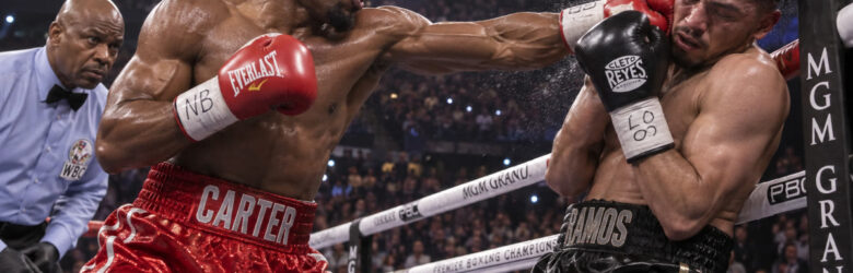 Two welterweight boxers in a boxing ring under bright spotlights at fight night