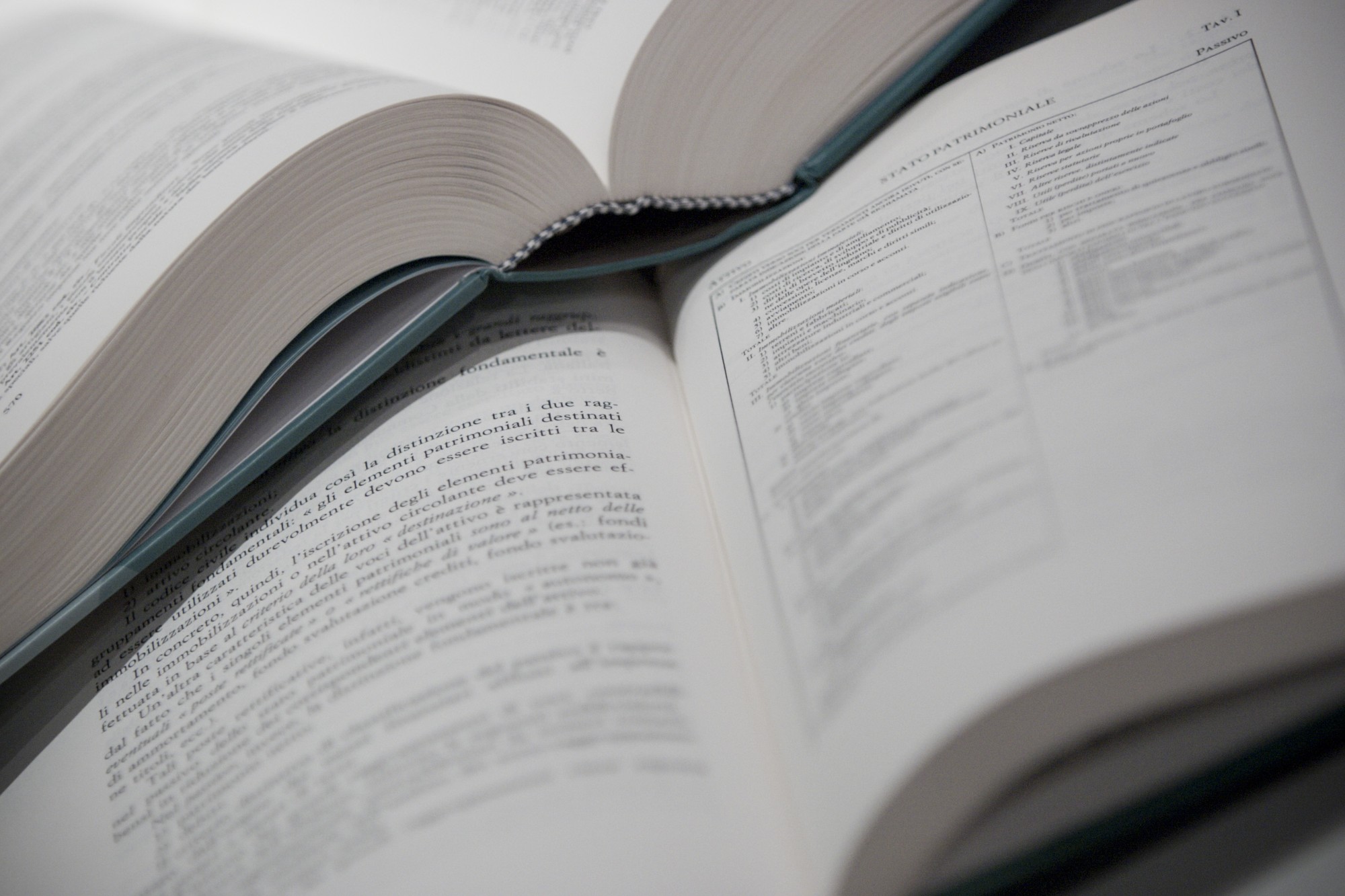 Two open Italian legal hardback books on a surface