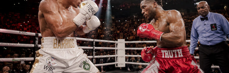 Two boxers in a boxing ring under bright arena lights
