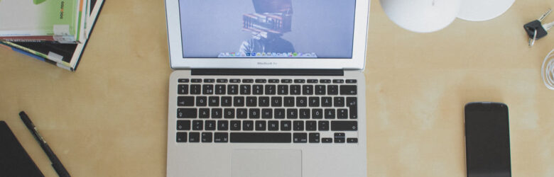 Laptop computer on a wooden desk, illustration for MapQuest app story