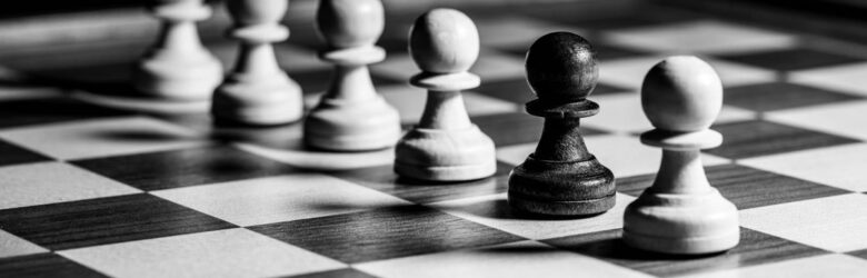 Black and white chess pawns on a board, representing the strategy of choosing and benchmarking local LLM models