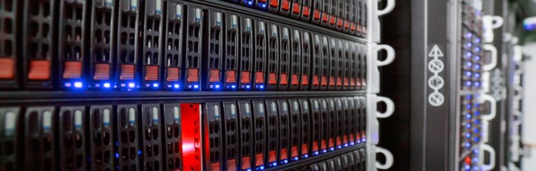 Rows of server racks with colourful network cabling inside a data center